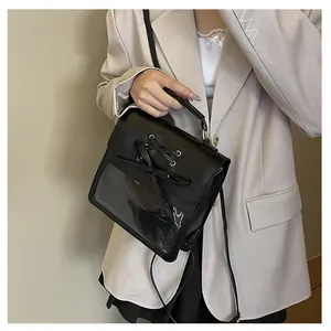 Detail of black ita bag featuring a transparent PVC window and decorative bow accent