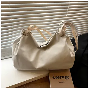 Detail of the soft cream faux leather tote bag with adjustable straps in a minimal setting