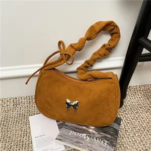 Brown suede underarm bag with silver butterfly buckle and pleated shoulder strap design