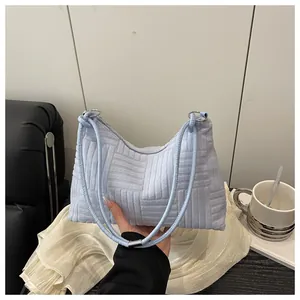 Détail du sac à bandoulière en velours côtelé bleu clair avec anneaux argentés