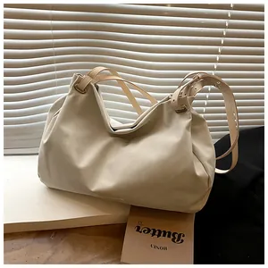 Detail of off-white oversized pleated tote bag with adjustable strap and vintage hardware