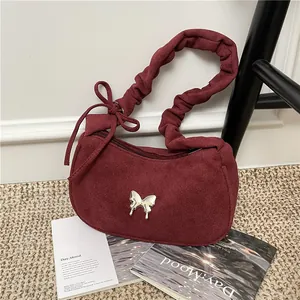 Burgundy suede underarm bag with pleated handle and silver butterfly buckle detail