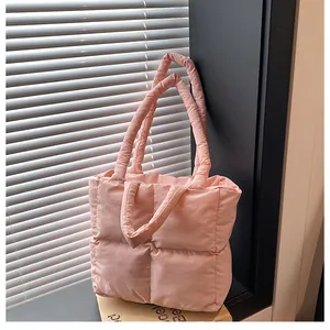 Close-up of pink quilted tote bag with soft padded texture and square stitching patterns