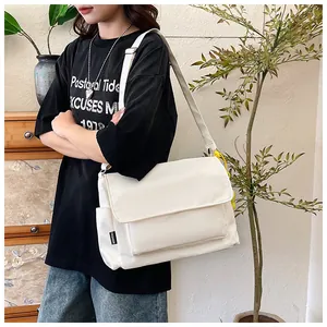 Détail latéral d'un sac bandoulière en nylon blanc avec étiquette mode et poche