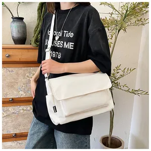 Détail du sac bandoulière en nylon blanc avec étiquette FASHION et sangle réglable