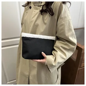 Dettaglio della borsa a mano nera con bordo in shearling bianco e trama in ecopelle