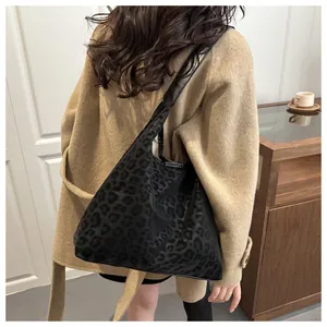 Close-up of stylish black leopard print PU shoulder bag in a warm lifestyle setting