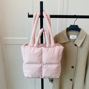 Pink quilted puffer tote bag in soft nylon shown with a stylish trench coat