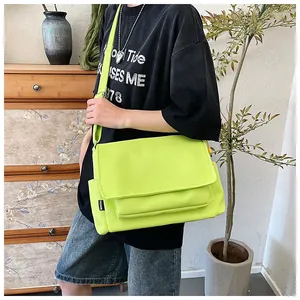 Détail du sac bandoulière en nylon vert fluo avec étiquette mode et poches multiples