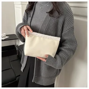 Dettaglio della borsa tote in pelle beige con bordo in shearling sintetico e cerniera
