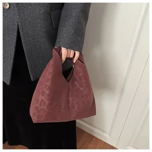 Detail of burgundy leopard print tote bag with minimalist triangular handle design