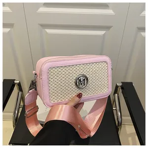 Detail of pink leather camera bag with woven panel and wide nylon shoulder strap