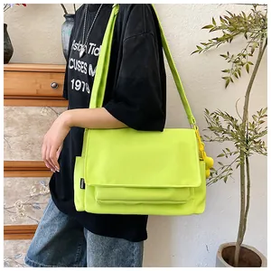 Détail du sac bandoulière en nylon vert fluo avec étiquette de mode et texture canevas
