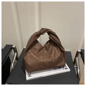 Detail of twisted handle and leopard print texture on a soft brown oversized tote bag