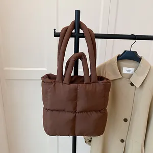 Brown quilted puffer tote bag with large square stitching and dual handles in soft nylon