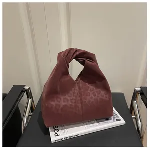 Detail of burgundy leopard print tote bag with soft texture and knotted handle design