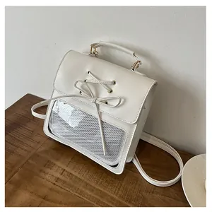 Detail of white PU leather backpack featuring cross-lace bow and clear window for pins