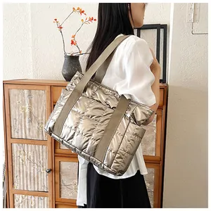 Detail der silbernen gesteppten Puffer-Tasche mit Seitentaschen und breiten Trägern