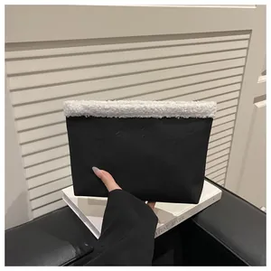 Dettaglio della tote borsa in pelle nera testurizzata con bordo in lana bianca
