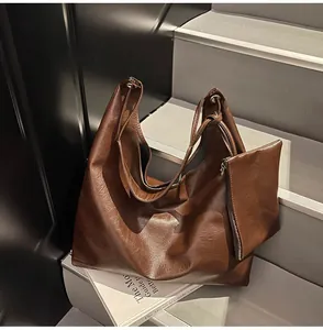Detail view of large brown tote bag with mini pouch on minimalist stairs setup