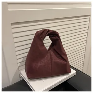Detail of burgundy leopard print tote with twist handle on minimalist white background
