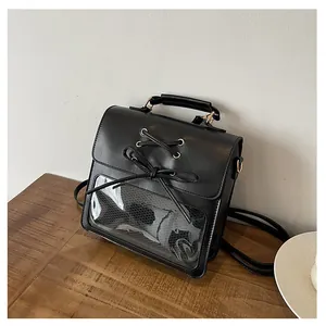 Detail of black PU leather ita bag with clear PVC window and cross lace-up ribbon bows