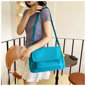 Détail du sac bandoulière en nylon bleu vif avec étiquette fashion et sangle réglable