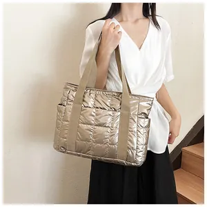 Detailaufnahme der gesteppten Metallic-Tasche in Champagner mit breiten Trägern