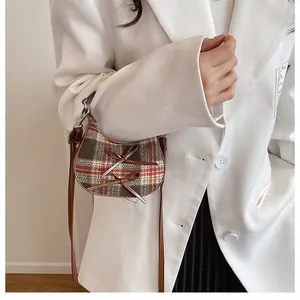 Detailed view of women's mini crescent bag with plaid wool fabric and leather bows