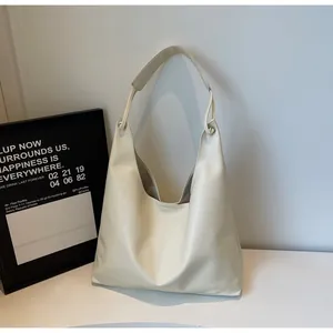 Detail of the soft cream faux leather hobo bag with wide shoulder strap and metal rings