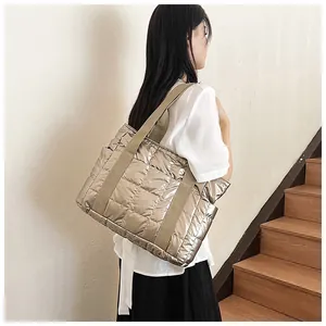 Detail der champagnergoldenen gesteppten Tragetasche mit Metallic-Finish am Modell getragen