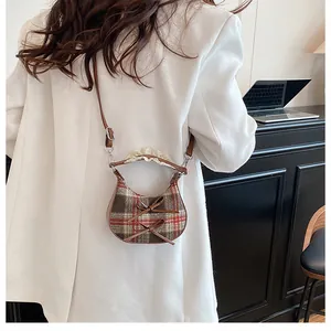 Mini plaid crossbody bag with brown bows and lace trim decoration on white blazer