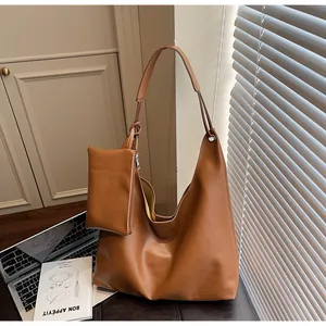 Detail of caramel brown tote bag with matching coin purse in an aesthetic indoor setting