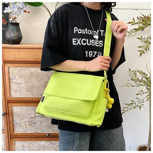 Détail du sac bandoulière en nylon vert fluo avec étiquette mode et sangle large