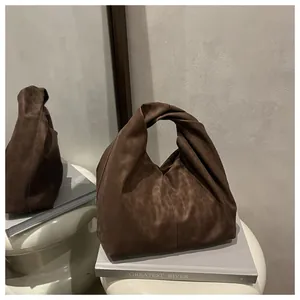 Close-up of knot handle detail on deep brown leopard print suede tote bag