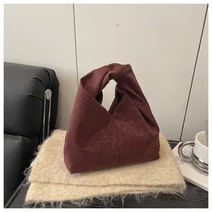 Close-up of burgundy leopard print tote bag with a unique knot handle on cozy knitwear