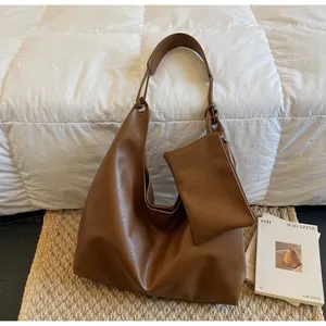 Detail of dark brown leather hobo bag with matching small zippered accessory pouch