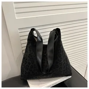 Detail of black leopard print hobo tote bag with soft faux fur texture and leather handles