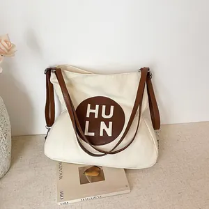Versatile off-white canvas tote bag with brown PU straps and circular HULN logo detail