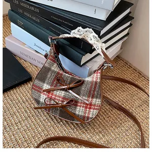 Detailed view of mini plaid handbag with lace trim handle and brown leather bows