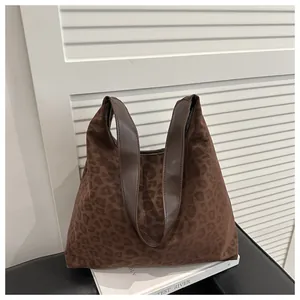 Detail shot of large leopard print tote bag with premium leather handles and texture