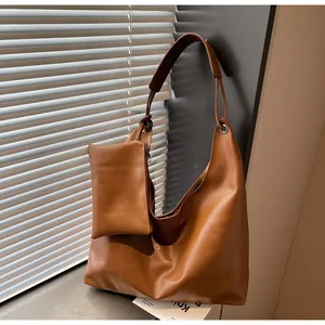 Detail of caramel brown hobo tote with textured faux leather and matching mini pouch