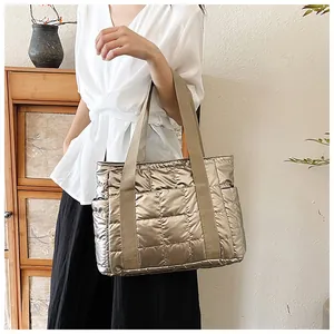 Makroansicht der gesteppten Puffer-Tasche in Metallic-Champagner mit Seitentaschen