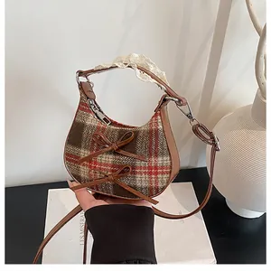 Detail of vintage brown plaid handbag with bow accents and delicate lace handle trim