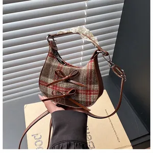 Detail of checkered crescent bag with bow accents and lace-wrapped handle detail