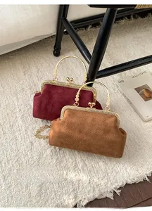 Detail geprägter Retro-Samttaschen in Burgunder und Braun mit Metallrahmen-Verschluss