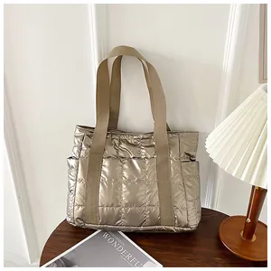Detaillierte Nahaufnahme der champagnergoldenen Stepptasche mit Seitentaschen und Glanz