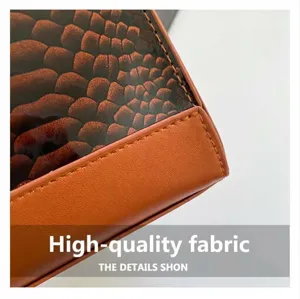 Detail view of caramel brown faux leather with snake print trim and precise stitching
