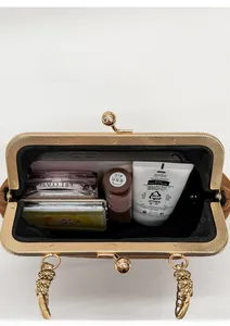 Innenansicht der braunen Wildleder-Clutch mit goldener Kette und Alltagsgegenständen