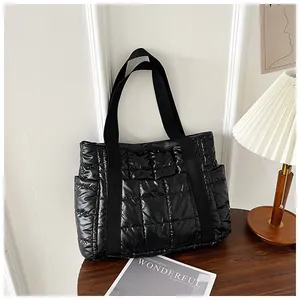 Detail einer glänzenden schwarzen Stepptasche mit quadratischen Nähten und Seitentaschen